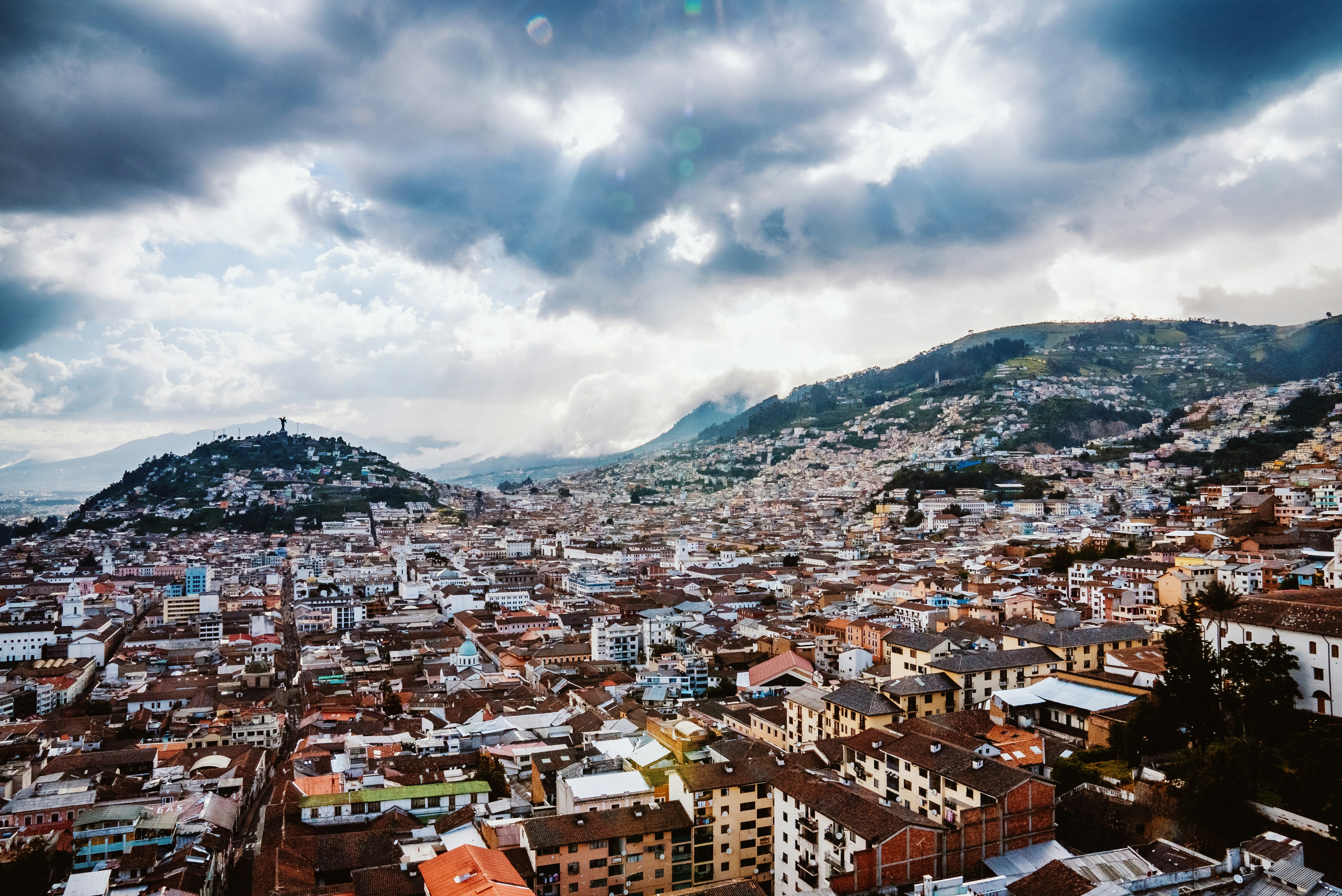 Vue panoramique sur le centre historique coloré de Quito entouré par les montagnes.